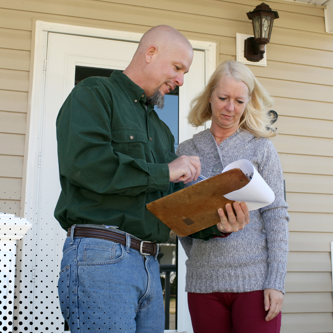 A home inspector and the homeowner go through the inspection report on a clipboard. 