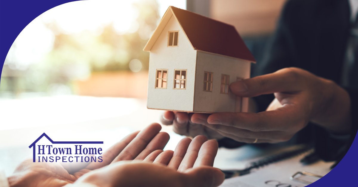 Hands holding a miniature house model, symbolizing home inspection and ownership.