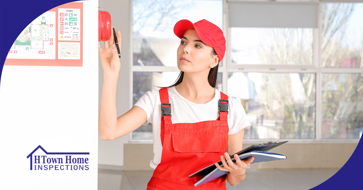 Female inspector in a red uniform testing a fire alarm system in a building during a safety inspection