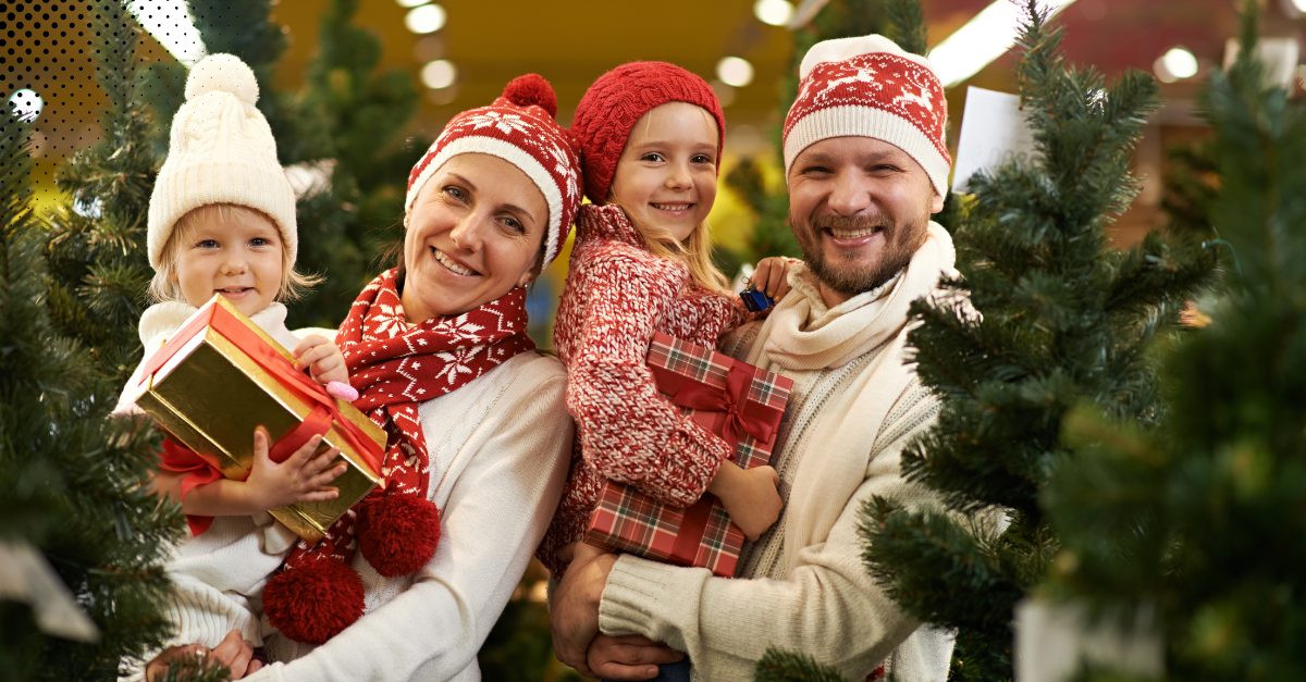 Happy family picking Christmas trees, spreading holiday cheer and joy.