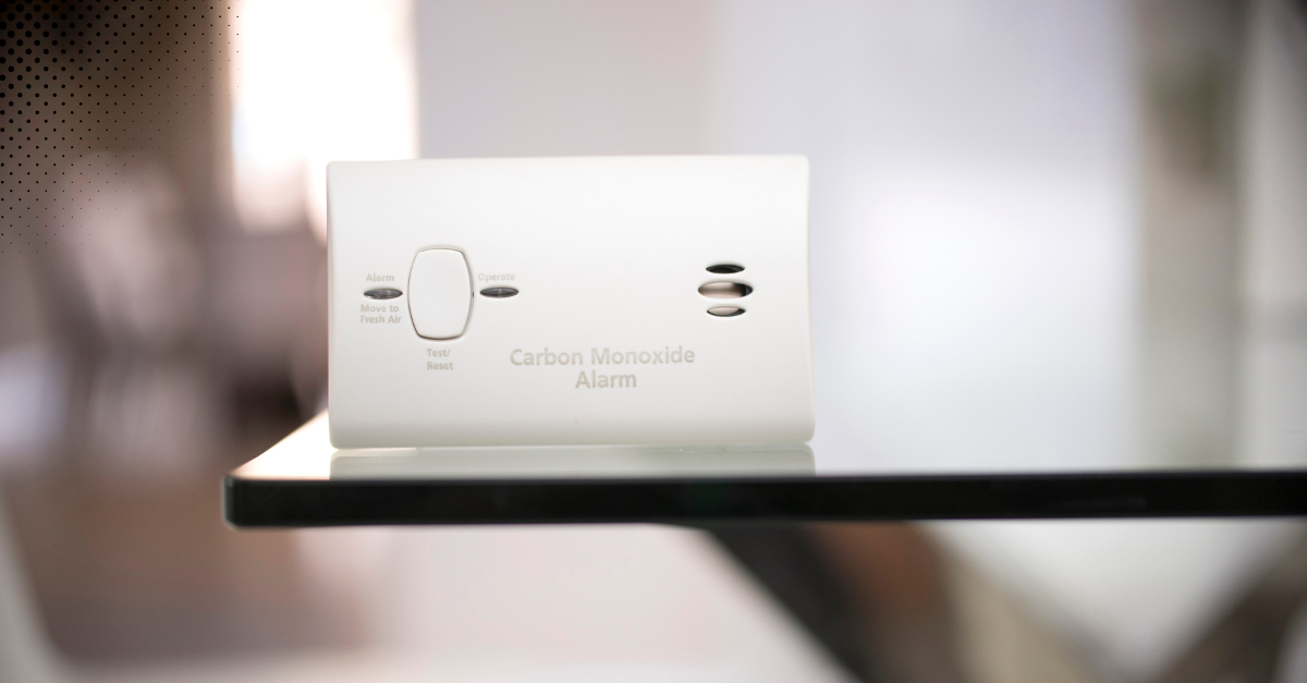 Carbon monoxide detector placed on a glass surface in a modern home