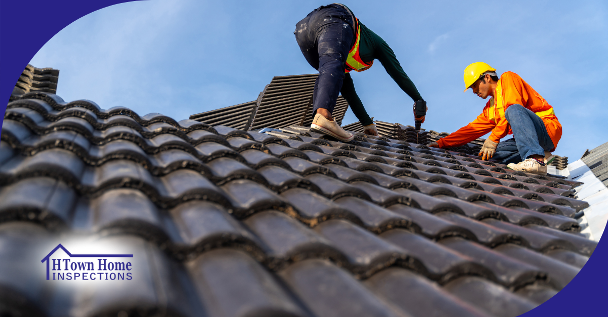 Two roof inspectors installing roof tiles with safety gear on a clear day.