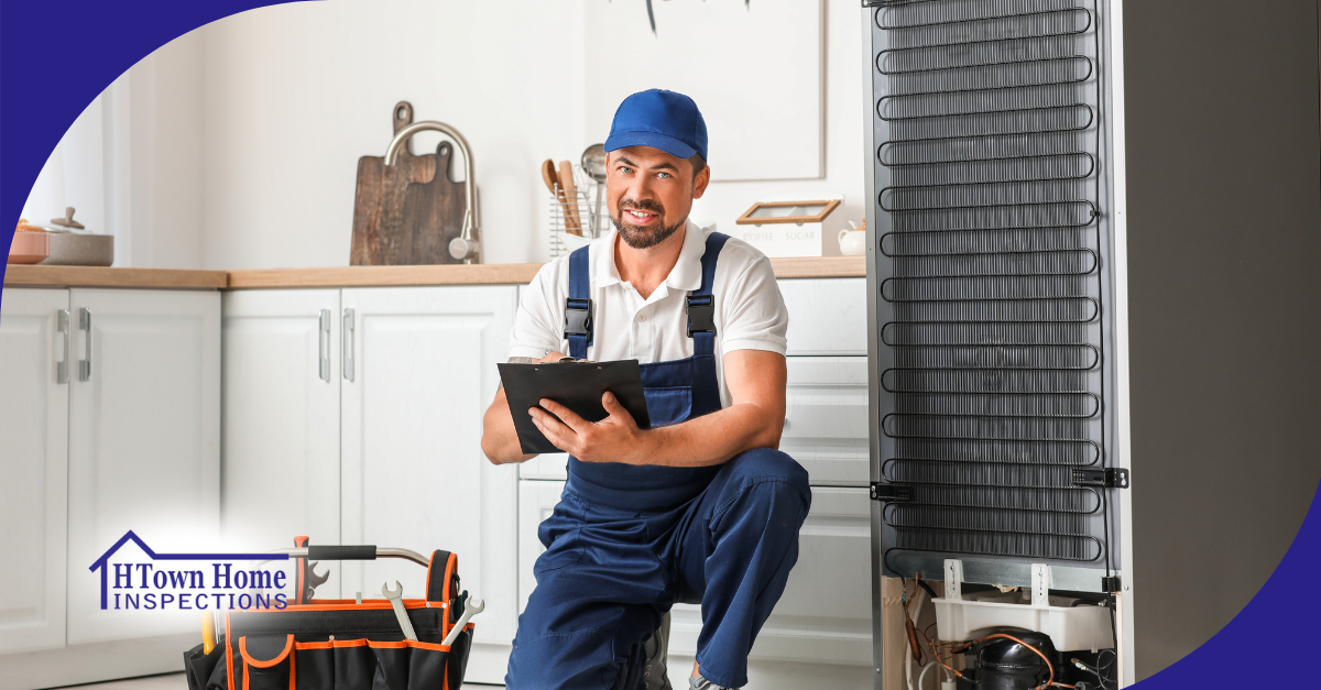 Home inspector kneeling in a kitchen, taking notes beside an open refrigerator.