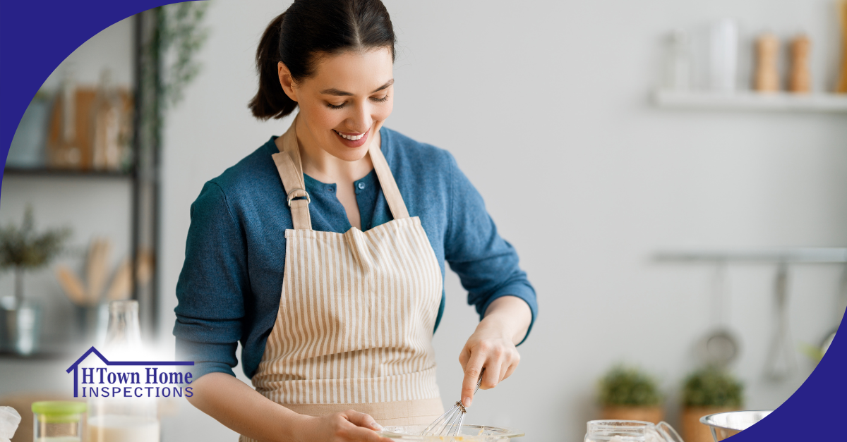 Woman smiling while whisking ingredients in a bowl in a bright kitchen.
