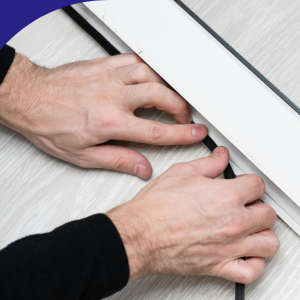 Hands installing weatherstripping on a sliding door.