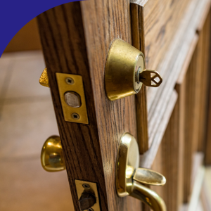 Key inserted in a front door lock with the door slightly open.