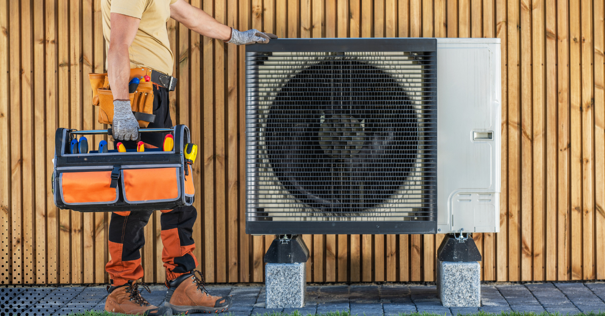 HVAC technician inspecting and servicing an outdoor AC unit.