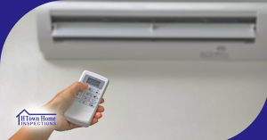 Hand using remote to control a wall-mounted air conditioner.